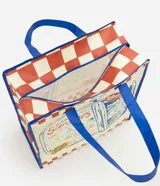 Bolsa de compras amplia de formato rectangular, confeccionada en material plástico resistente. Presenta un diseño a cuadros en tonos blanco y rojo, con asas dobles reforzadas y ribetes en color azul. Cuenta con una gran ilustración frontal estilo ilustración de lata de sardinas y detalles de texto.