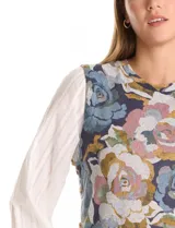 Buzo combinado con torso de tejido fino estampado con diseño floral en tonos azules, grises y rosados. Presenta mangas largas de gasa liviana en color blanco con puños elásticos y botones funcionales en los laterales del ruedo.