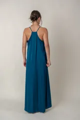 Vestido largo de seda en color azul petróleo, con escote en V, breteles finos y bolsillos laterales. Diseño holgado y fluido.