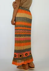 Pollera larga tejida a crochet con diseño de rayas horizontales en tonos naranja, fucsia y morado.