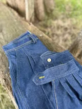 Pantalón de jean azul oscuro, de corte recto, con bolsillos laterales y traseros.