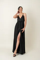 Vestido largo negro de satén, con breteles finos, escote en V cruzado y tajo lateral alto.