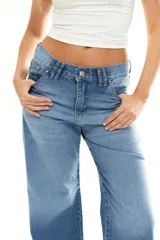 Jean de corte recto y tiro medio, confeccionado en denim de algodón con lavado azul clásico. Presenta diseño de cinco bolsillos, cierre frontal con botón metálico y costuras reforzadas.