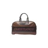 Bolso duffle de diseño espacioso, confeccionado en cuerina marrón con una franja horizontal marrón oscura al frente que lleva impreso el nombre de la marca 'EMESTUDIOS'. Cuenta con asas dobles de mano y un bolsillo frontal con cierre metálico.
