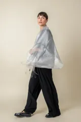 Chal de organza con tejido de lurex brillante, diseño ligero y traslúcido con terminación de flecos en los extremos.