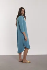 Vestido camisero midi con estampado floral en tonos naranja, rosa y fucsia. Tiene cuello camisero, mangas 3/4 y aberturas laterales.