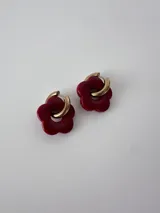 Aros de acero quirúrgico dorados en forma de argolla con dije colgante en forma de flor color bordo de resina.