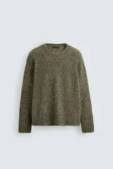 Jersey de corte relajado con textura rizada, cuello redondo y manga larga. Presenta acabados en rib en puños y ruedo.