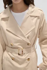 Trinchera de corte clásico, color negro, con cierre frontal de doble botonadura, solapas amplias y cinturón ajustable con hebilla en la cintura.