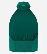 Top cropped de crepé color verde esmeralda, con escote halter y cuello alto. Presenta un canesú fruncido en la cintura que ajusta la prenda al cuerpo.
