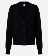 Cardigan corto de punto color bordó, con escote en V, mangas largas y cierre frontal con botones. Presenta puños y bajo acanalados.
