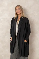 Saco tipo cárdigan largo de color chocolate, con frente abierto, mangas largas y bolsillos laterales amplios. Presenta una caída fluida y un diseño minimalista y elegante.