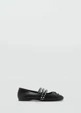 Zapato tipo ballerina color negro, con punta redondeada y triple tira con hebilla y tachas plateadas.