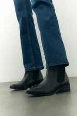 Botinetas negras de cuero con elástico lateral y taco bajo.