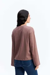 Remera de manga larga color marrón con estampa frontal con la frase 'Pasta Lover Club' y dibujos de un tenedor con pasta y tomates. Presenta un corte holgado y cuello redondo.