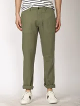Pantalón de lino color verde oliva, de corte recto y con ruedo arremangado.