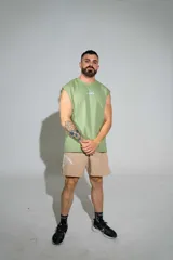 Musculosa verde militar de algodón elastizado, con cuello redondo y diseño holgado sin mangas. Cuenta con pequeño estampado gráfico en el centro del pecho.