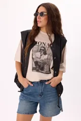Remera color beige de corte amplio con mangas cortas y cuello redondo. Estampado frontal con la palabra "Monaco" en la parte superior y una fotografía en blanco y negro con la frase "Mont Carlo" en la parte inferior.