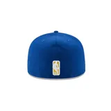 Gorro New Era azul con visera plana y logo bordado de los Golden State Warriors en amarillo.