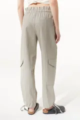 Pantalón cargo color gris topo de lino metalizado, con cintura alta elastizada y lazo de ajuste.