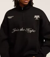 Buzo negro de algodón con felpa, corte boxy, cuello alto con cremallera, mangas largas con puños ajustados y bordado con la frase "Join the hype".