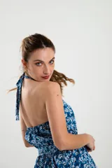 Mono corto color ocre con estampado floral en tonos rosados, con cuello halter y lazo en la cintura.