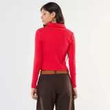 Camiseta roja de punto calado con cuello polo y mangas largas.