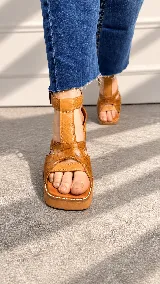 Sandalias de taco alto ancho con plataforma, color tostado, con tiras delanteras entrelazadas en cuero grabado tipo cocodrilo y capellada lisa, tiras laterales y correa al tobillo con hebilla metálica ajustable.