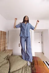 Conjunto de pijama azul a rayas blancas, compuesto por camisa de manga corta con botones y pantalón largo de corte amplio.