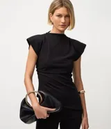 Blusa negra de crepé con cuello alto, mangas cortas con hombreras y bajo asimétrico con bico lateral.