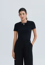 Top de manga corta, color negro, con cuello redondo y tejido acanalado.