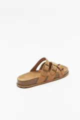 Sandalias negras con plataforma de corcho de 3 cm de alto y tiras cruzadas de gamuza con hebillas metálicas ajustables.