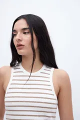 Musculosa blanca con rayas horizontales color café, de corte ajustado y cuello redondo.