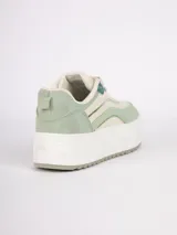 Zapatilla de plataforma con diseño de recortes en tonos blanco, beige y detalles metalizados plateados. Cuenta con suela texturizada y cierre mediante cordones.