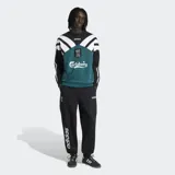 Buzo de cuello redondo Adidas, inspirado en la temporada 95/96 del Liverpool FC. Presenta un diseño de bloques de color en verde, negro y blanco, con el escudo del club y el logo de Carlsberg en el frente. Confeccionado en felpa de algodón con corte holgado.