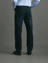 Pantalon denim de cinco bolsillos, corte recto y color negro, con botones y remaches metálicos en tono plata viejo.