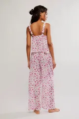Conjunto de dos piezas de algodón con estampado floral en tonos rosados sobre base blanca, compuesto por una camisola sin mangas con escote cuadrado y lazo frontal, y pantalón largo de corte ancho.