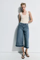 Bermuda larga de jean color azul, tiro medio, con diseño wide leg y bolsillos. Cuenta con bajo desflecado y cierre frontal con cremallera y botón metálico.