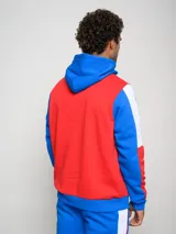 Canguro de felpa Umbro del Club Nacional de Football, con diseño tricolor en rojo, azul y blanco. Presenta capucha con cordones ajustables, bolsillo tipo canguro frontal, logo de la marca y escudo del club bordados en el pecho.