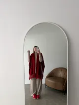 Ruana negra de tejido liviano con terminación de flecos en el ruedo y mangas amplias.