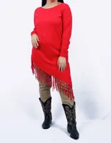 Buzo rojo de punto con cuello redondo y mangas largas. Presenta un corte irregular con terminación de flecos en el ruedo.