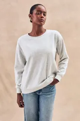 Sweater gris melange de algodón peinado con poliéster, de calce oversize, cuello redondo y mangas largas.