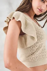Top de punto calado color beige con brillo metalizado, escote redondo y mangas cortas con volados.