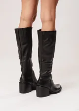 Bota de caña alta negra de cuero con taco cuadrado.