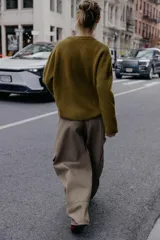 Jersey de punto negro, con cuello en V (pico) y manga larga, acabado en rib en puños, cuello y bajo.