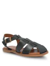 Sandalias planas de cuero negro, diseño tipo romano con tiras anchas entrelazadas en el empeine, tira ajustable con hebilla metálica en el tobillo y suela marrón.
