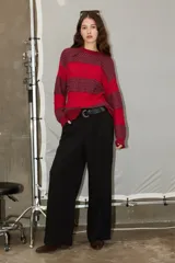 Sweater de tejido jacquard con diseño de rayas horizontales en tonos rojo y bordó, de corte holgado, cuello redondo y manga larga.