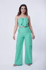 Conjunto de dos piezas color verde menta, compuesto por un top corto con breteles finos y detalle de lazo frontal, y un pantalón de corte recto tipo cargo con bolsillos laterales y cintura elástica.