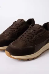 Championes urbanos de diseño técnico, combinando paneles de gamuza y tela técnica en tonos marrones. Presenta una entresuela de plataforma en color crema con suela dentada de goma.