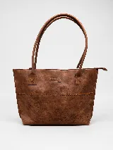 Cartera tipo tote bag de cuero vacuno color marrón oscuro, de diseño estructurado con asas largas para llevar al hombro y cierre superior. Presenta detalles de costuras decorativas y pespuntes en el frente.